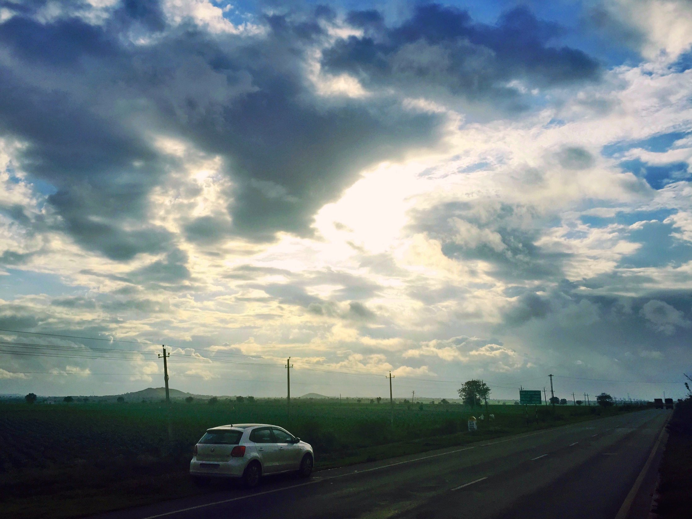 A lone car under a big sky â€” the Puneâ€“Bangalore highway near Hubballi. â€” Karnataka Â· Aug 2015